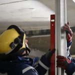 Zwei Personen in Einsatzbekleidung des THW messen mit einer Wasserwaage die Ausrichtung einer Stütze.
